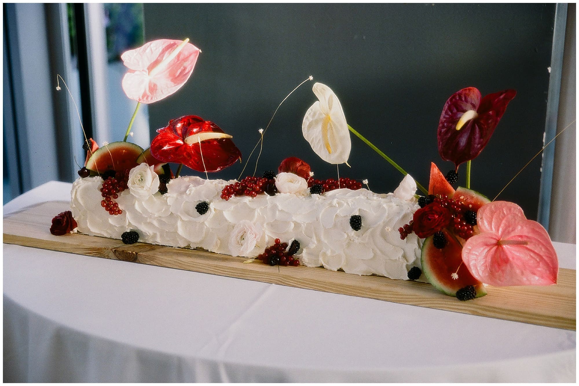 A close-up detail of the reception floral centerpiece at Virgin Hotels NYC in New York City. White anthurium blooms and deep red florals create a sculptural, modern arrangement by the couple's Manhattan wedding florist.